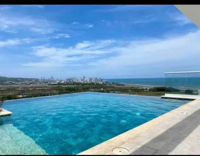 a large swimming pool with a view of the ocean at Como estar en casa! in Cartagena de Indias