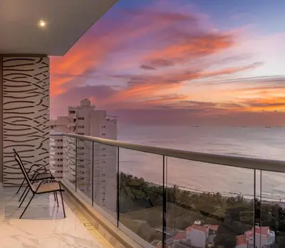a balcony with a view of the ocean at sunset at Apto de Lujo con Vista al Mar en Playa Bello Horizonte in Santa Marta