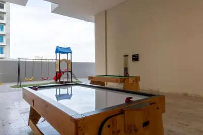 a ping pong table in a room with two play equipment at Apto de Lujo con Vista al Mar en Playa Bello Horizonte in Santa Marta