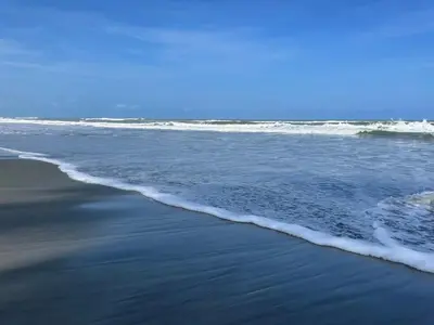 an empty beach with waves in the ocean at Shambala Beach House in San Bernardo del Viento