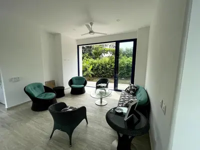 a living room with green chairs and a table at Shambala Beach House in San Bernardo del Viento