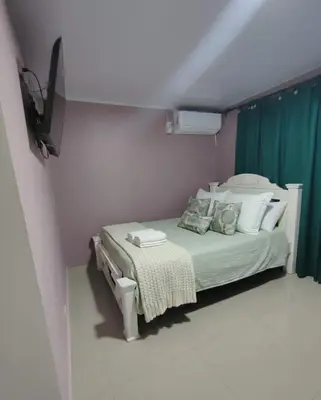 a bedroom with a bed with a green curtain at Casa Plenitud Lux in Cartagena de Indias