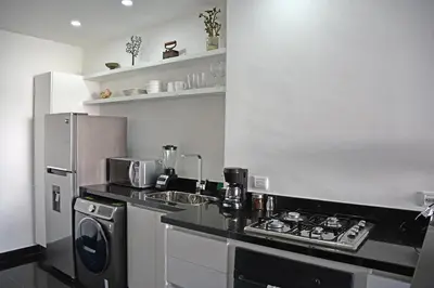 a kitchen with a stove top oven next to a refrigerator at Apartamento en cartagena - cristoforo piso 7 in Cartagena de Indias