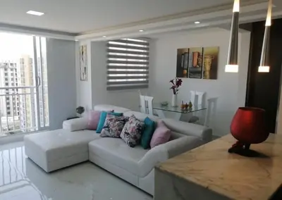 a living room with a white couch with colorful pillows at Alquiler Apartamento Amoblado in Barranquilla