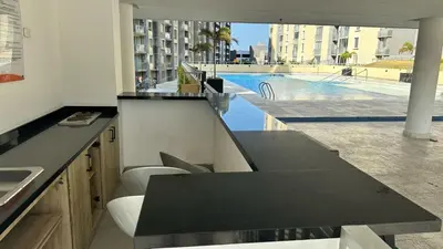 a kitchen with a black counter and a swimming pool at Norte de Barranquilla in Barranquilla