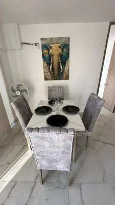 a table and chairs with an elephant painting on the wall at Norte de Barranquilla in Barranquilla