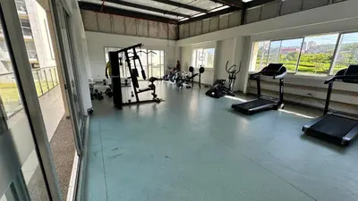 a gym with several treadying machines in a room with windows at Norte de Barranquilla in Barranquilla