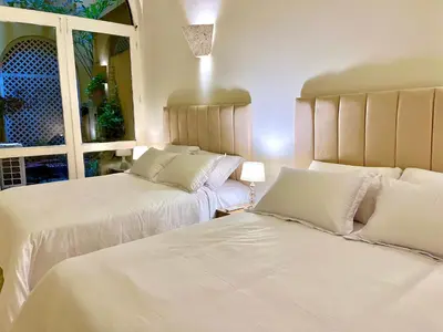 two beds sitting next to each other in a bedroom at by Calamari Homes - El Porvenir 206 walled city in Cartagena de Indias