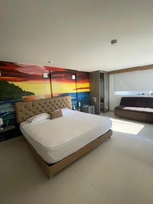 a bedroom with a large bed and a painting on the wall at HS-DD Habitación Deluxe cerca al mar con piscina y wifi in Cartagena de Indias