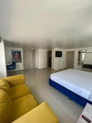 a bedroom with a large bed and a couch at HS-DD Habitación Deluxe cerca al mar con piscina y wifi in Cartagena de Indias