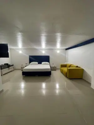 a bedroom with a bed and a yellow couch at HS-DD Habitación Deluxe cerca al mar con piscina y wifi in Cartagena de Indias