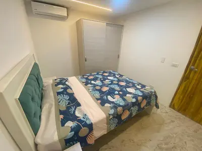 a small bedroom with a bed with a blue blanket at Casa de lujo en barrio popular in Cartagena de Indias