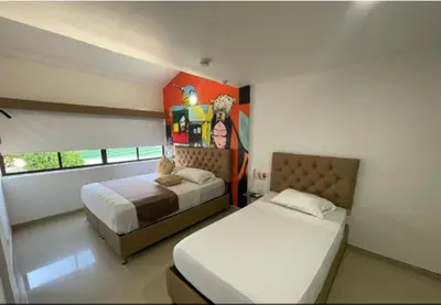 a bedroom with two beds and a painting on the wall at HS-T Habitacion Triple con wifi, piscina y aire acondicionado in Cartagena de Indias