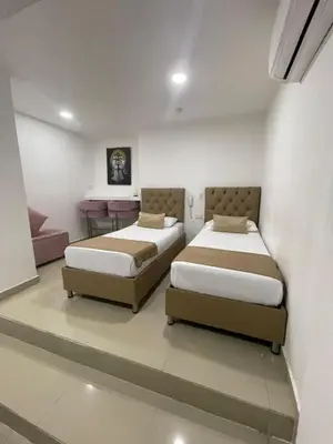 a bedroom with two beds and a couch at HS-T Habitacion Triple con wifi, piscina y aire acondicionado in Cartagena de Indias