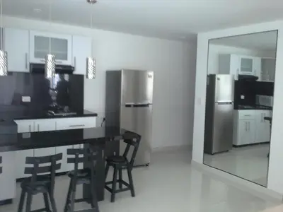 a kitchen with a stainless steel refrigerator and stools at Arriendos S.H. Nuevo Conquistador in Cartagena de Indias