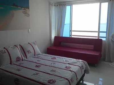 a bedroom with a bed and a couch and a window at Arriendos S.H. Nuevo Conquistador in Cartagena de Indias