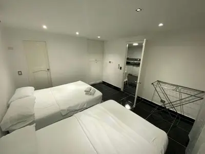 two white beds in a room with a mirror at Apartamento en Bocagrande muy cerca al mar! Apto 401 in Cartagena de Indias
