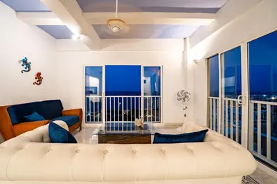 a living room with a white couch and a large window at Renovated with ocean view in historic center! in Cartagena de Indias