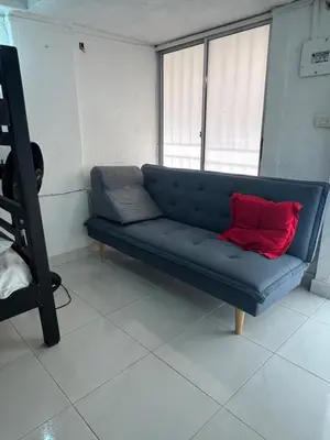 a blue couch with a red pillow in a room at Apartaestudio Marbella in Cartagena de Indias