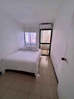 a small bedroom with a bed and two windows at Portofino Apartments in Cartagena de Indias