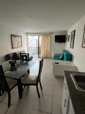 a kitchen and living room with a table and a couch at Portofino Apartments in Cartagena de Indias