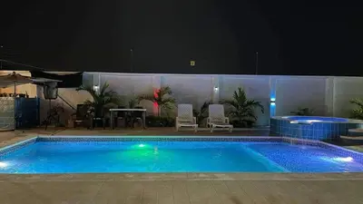 a large blue swimming pool with a table and chairs at Habitacion con piscina-jacuzzi-lavadora disponible in Juan de Acosta