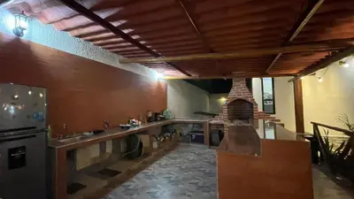 a large kitchen with a counter and a fireplace at Habitacion con piscina-jacuzzi-lavadora disponible in Juan de Acosta