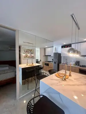 a kitchen and living room with a table and chairs at Apto de lujo para estrenar in Barranquilla