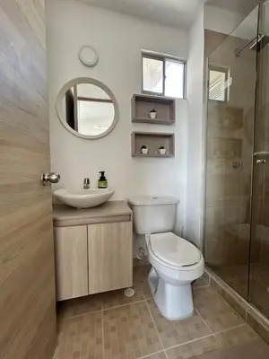 a bathroom with a toilet and a sink and a mirror at Cómodo apartamento en el norte de Barranquilla in Barranquilla