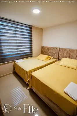 two beds in a room with a window at Suite Elite Barranquilla in Barranquilla
