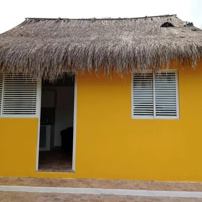a yellow house with a thatched roof at Dulce Barú in Cartagena de Indias
