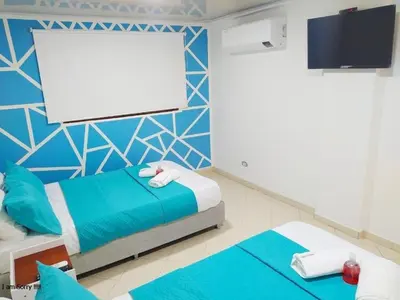 a room with two beds and a projection screen at comodo apto marbella b17 in Cartagena de Indias