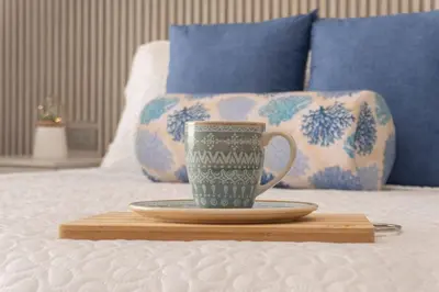 a coffee cup on a wooden tray on a bed at Suite Familiar Vista al Mar, Day Bed WiFi CB1315 in Cartagena de Indias