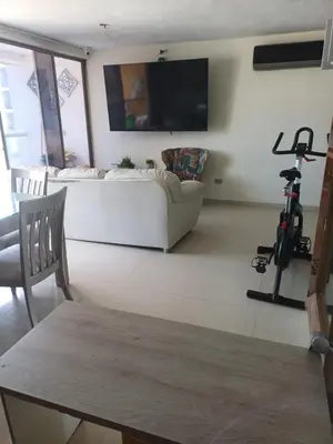 a living room with a white couch and a tv at Oporto in Barranquilla