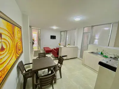 a living room with a dining table and a kitchen at Apartamento nuevo a 300 mts malecón del rio in Barranquilla