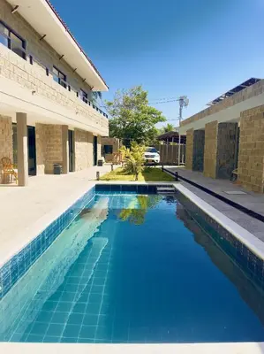 a blue swimming pool in front of a building at Villa pio blue in Santa Veronica