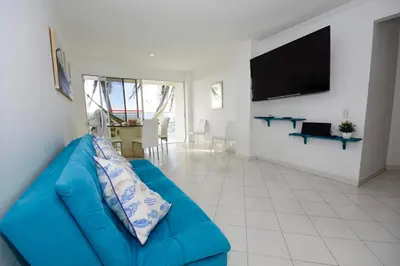 a blue couch in a living room with a flat screen tv at Frontbeach Apartment Cartagena HighSpeed internet in Cartagena de Indias