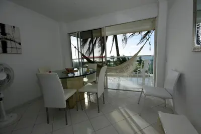 a dining room with a glass table and white chairs at Frontbeach Apartment Cartagena HighSpeed internet in Cartagena de Indias