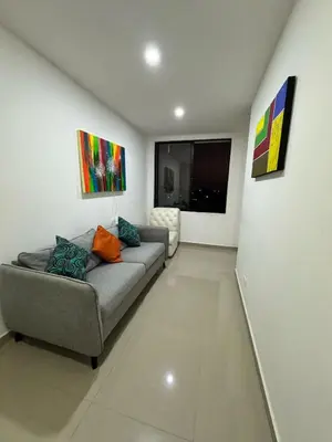 a living room with a couch and paintings on the wall at ApartaEstudio in Barranquilla