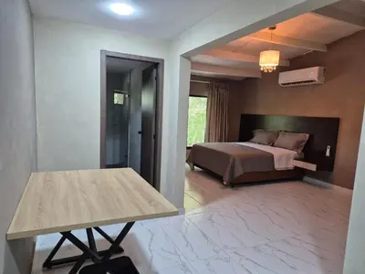 a bedroom with a bed and a table in it at Laureles del Parque Loft in Barranquilla