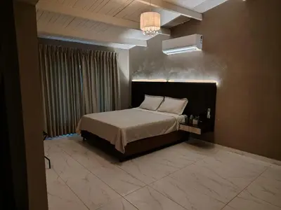 a bedroom with a bed and a chandelier at Laureles del Parque Loft in Barranquilla