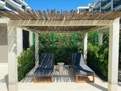 two blue chairs under a wooden pergola at Exclusivo apartamento con Piscina Privada in Cartagena de Indias
