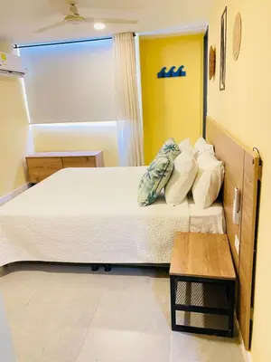 a bedroom with a large bed with white sheets and pillows at Laguito Houstel Small in Cartagena de Indias