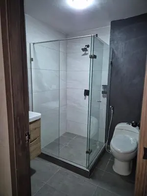 a glass shower in a bathroom with a toilet at Laureles del parque loft in Barranquilla