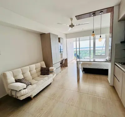 a living room with a white couch and a kitchen at Hermosa APARTASUITE EN CARTAGENA!! in Cartagena de Indias