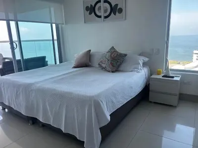 a bedroom with a bed with a view of the ocean at HERMOSO APARTAMENTO VISTA AL MAR PALMETTO SUNSET-El Laguito in Cartagena de Indias