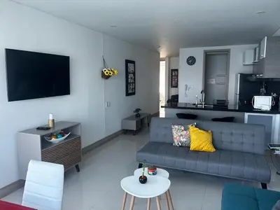 a living room with a couch and a kitchen at HERMOSO APARTAMENTO VISTA AL MAR PALMETTO SUNSET-El Laguito in Cartagena de Indias