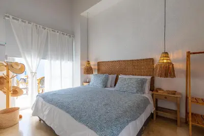 a bedroom with a bed with a blue comforter at Cabaña Tio Chin in Coveñas