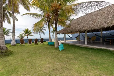 a resort with chairs and a hammock on the beach at Cabaña Tio Chin in Coveñas