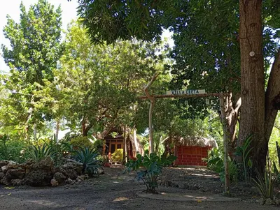 a street sign in a park with trees and a building at Hospedaje VILLA CRETA in Isla Fuerte